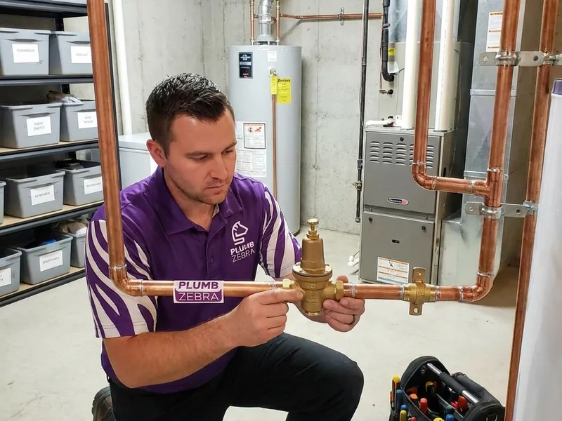 Professional plumber performing water pressure issues service